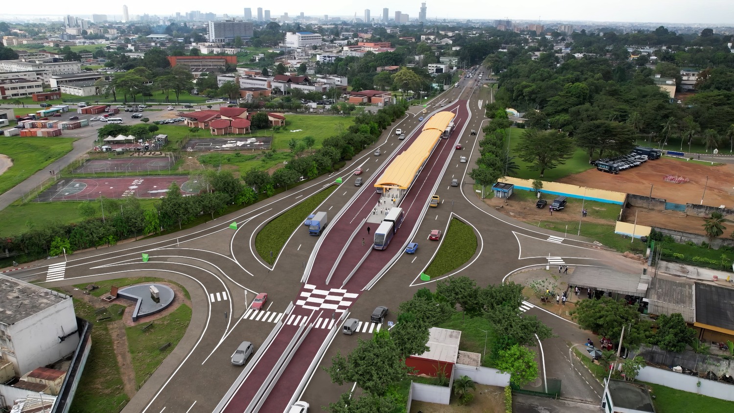 Aerial view of a multi-lane urban road with a central bus rapid transit station, vehicles, and surrounding greenery and city buildings in the background.