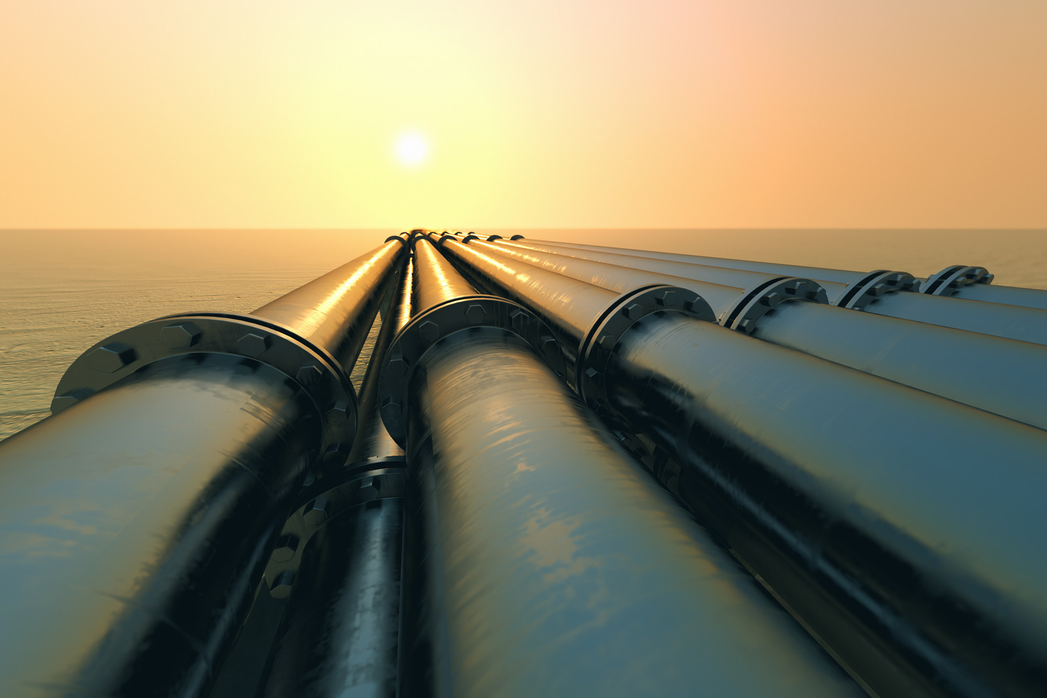Pipelines in the ocean at sunset.