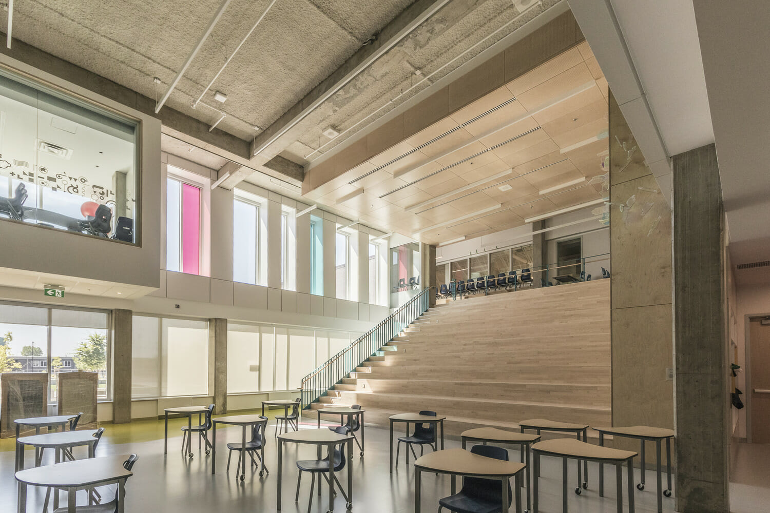 The interior of a school building with stairs and tables.