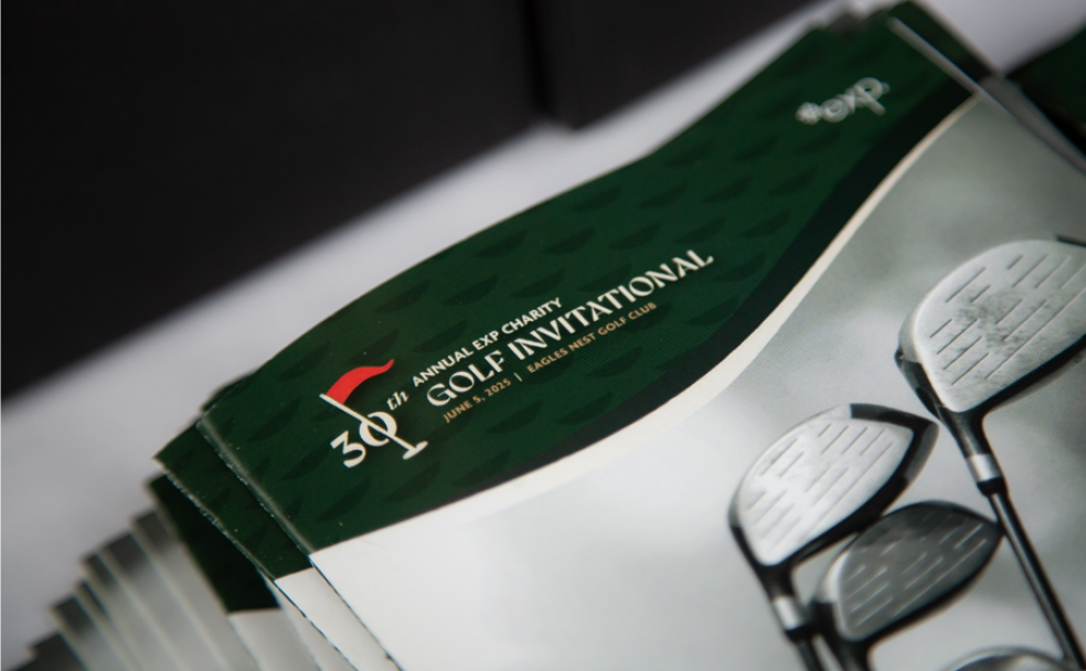 Close-up of printed programs for the 31st Annual EP Charity Golf Invitational, featuring images of golf clubs and event details on the cover.