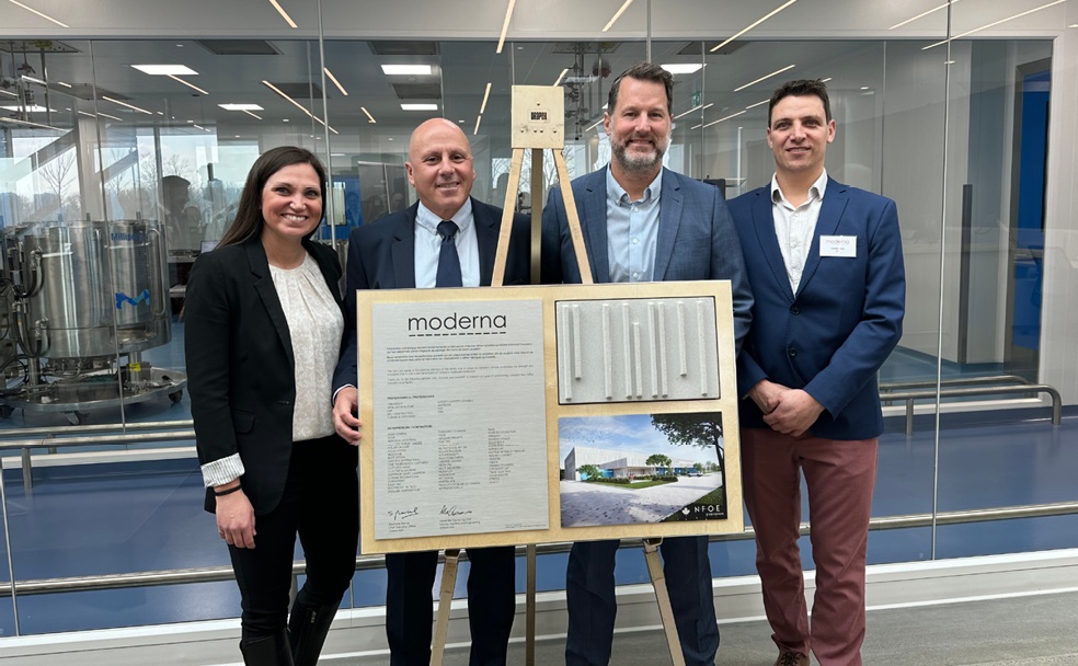 A group of people standing in front of a poster.